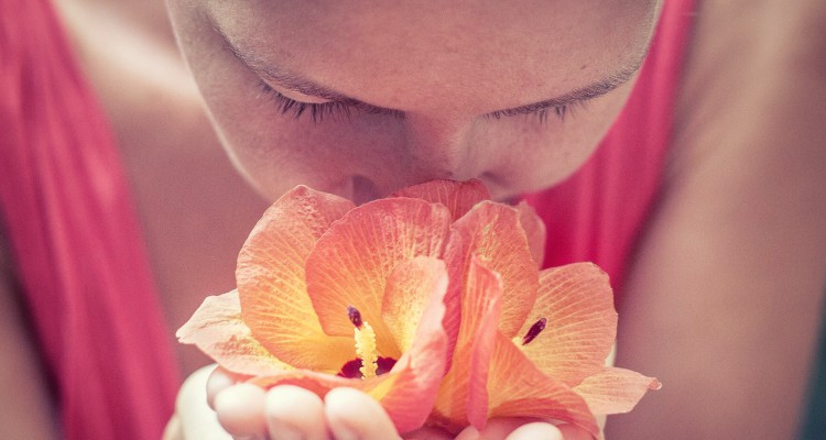 Woman smelling flower in her hands
