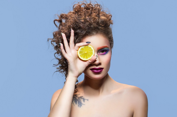 Makeup model holding lemon slice
