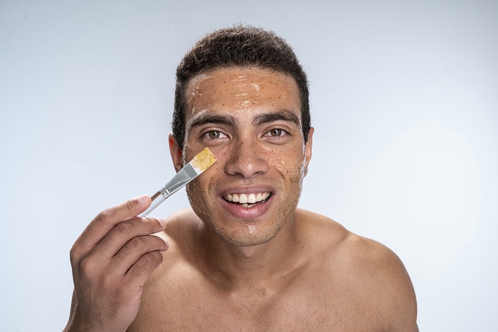 Man on his honey facial mask skincare at home