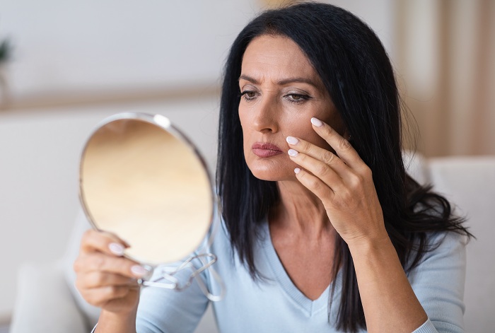 Mature woman checking her fine lines in the mirror