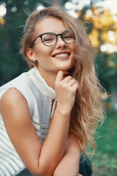 Modern age woman with clear skin wearing eyeglasses