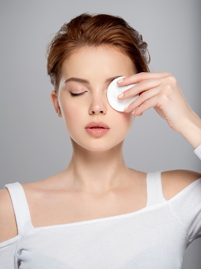 Pretty face of a woman holding a cotton on one hand