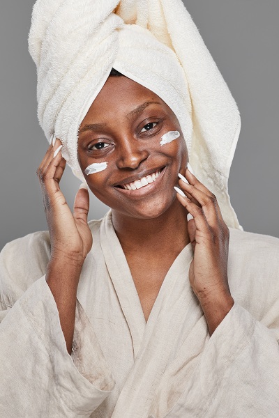Smiling African American Woman doing her skincare routine