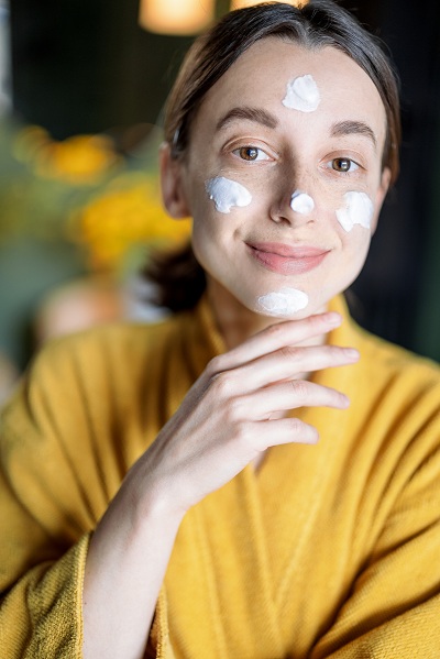 Woman applying face cream before her day starts