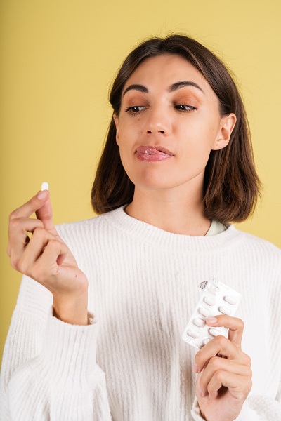 Woman taking gluta pills for her skincare
