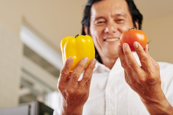 man holding veggies rich in vitamins a and e