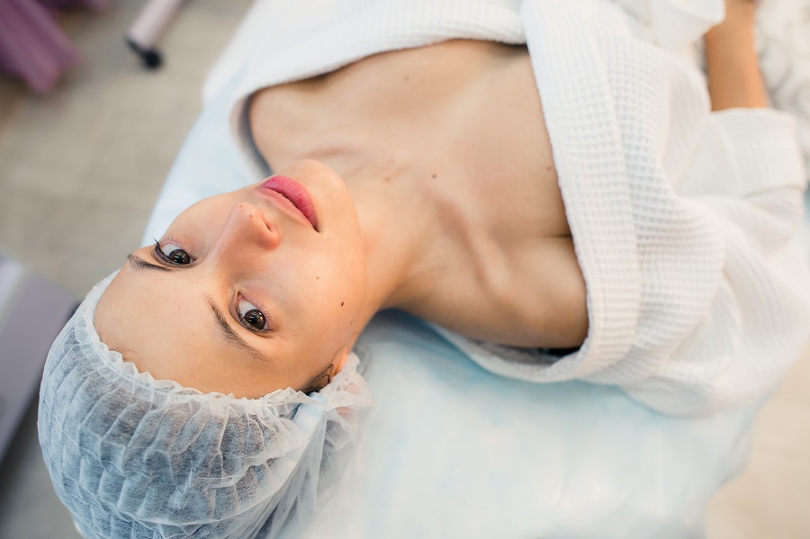 beautiful patient woman smile lying on bed in surgery room hospital