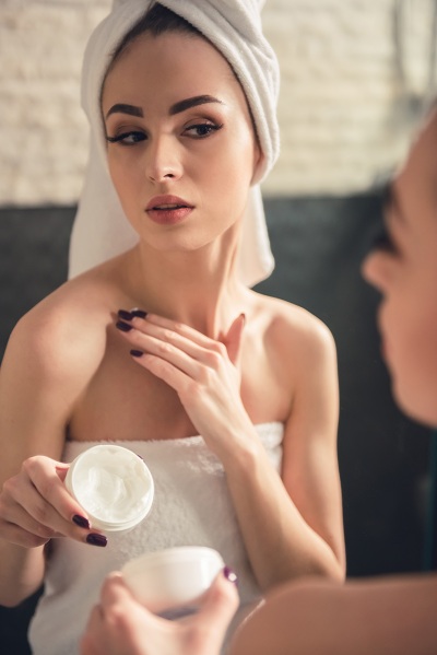 woman in the bathroom applying cream after bathing