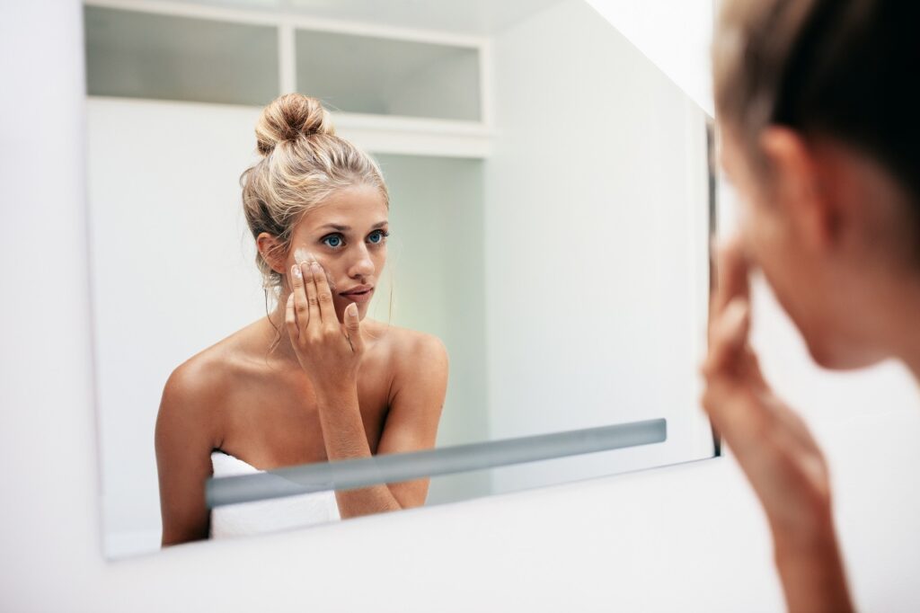 woman putting on facial cream