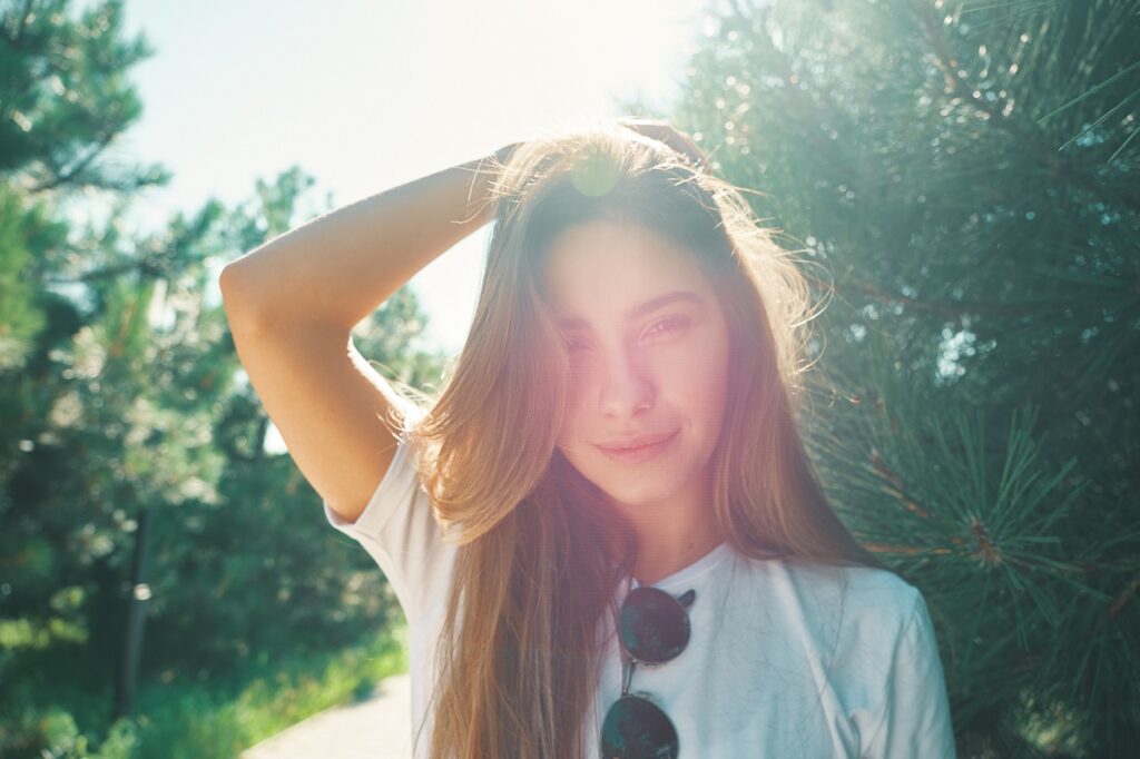 Close-up young woman with beautiful face features enjoying sun